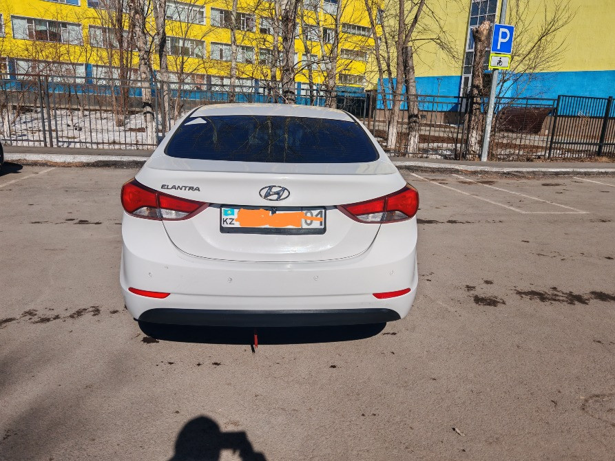 Ақ Hyundai Elantra автокөлігінің артқы жағы номерлік белгісімен