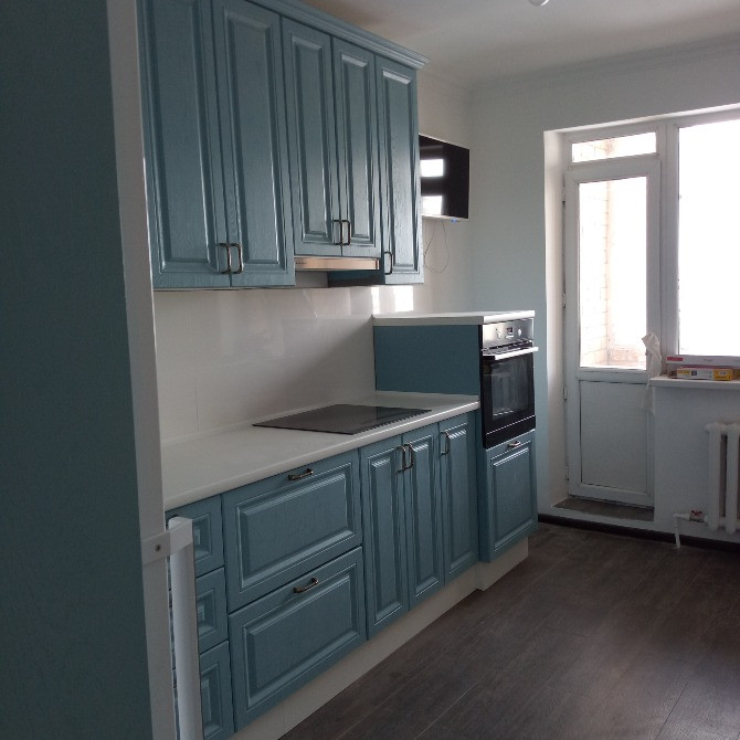 Заманауи асхана көк шкафтармен және ақ үстелшамен