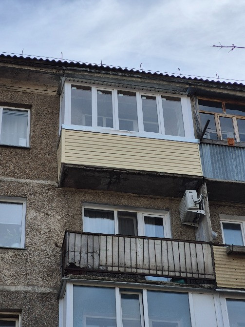 Балконға қосылған және терезелері бар ғимарат фасады