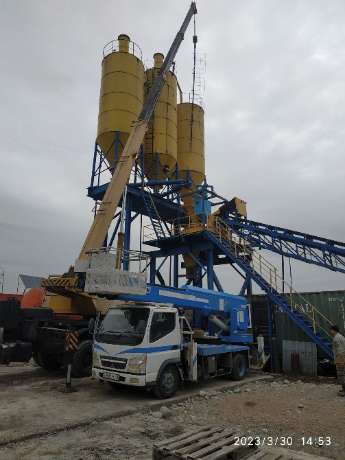 Подъем конструкции на стройплощадке с бетононасосом и грузовиком