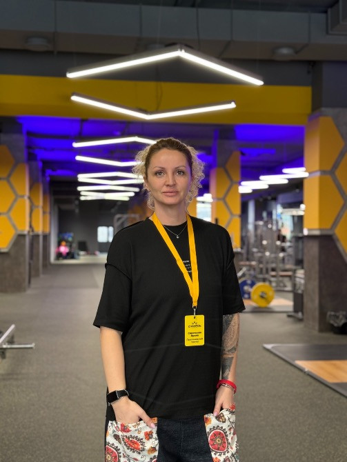 Фитнес-тренер в современном тренажерном зале с ярким освещением