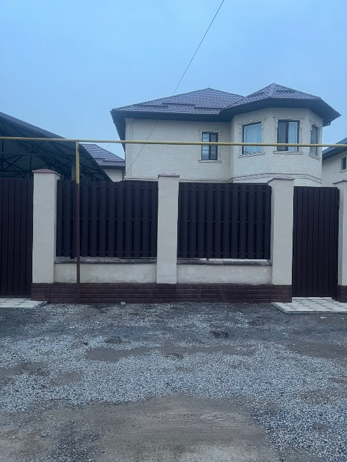 қоршауы бар үйдің фасады