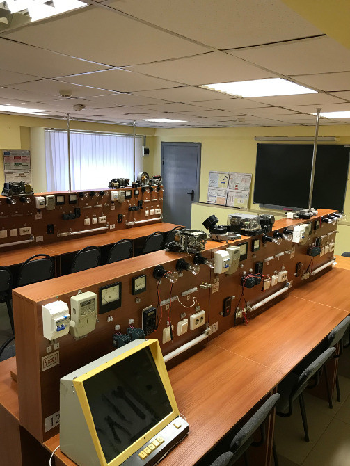 Учебная лаборатория с оборудованием и учебными приборами на столах, пустые стулья