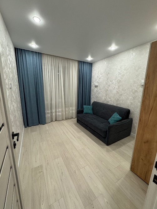 Перделермен және диванмен безендірілген бөлме