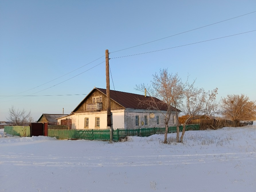 Дом под солнечным светом с белым снегом вокруг