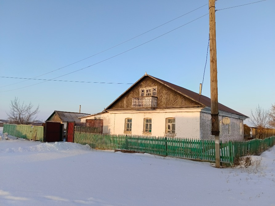 Вид на дом с зеленым забором и другими постройками