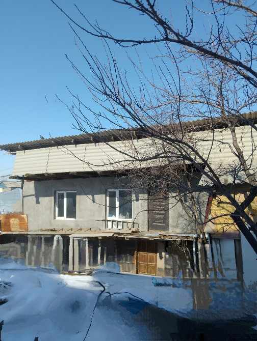 Вид на дом с чердаком, снежный двор, деревья без листьев