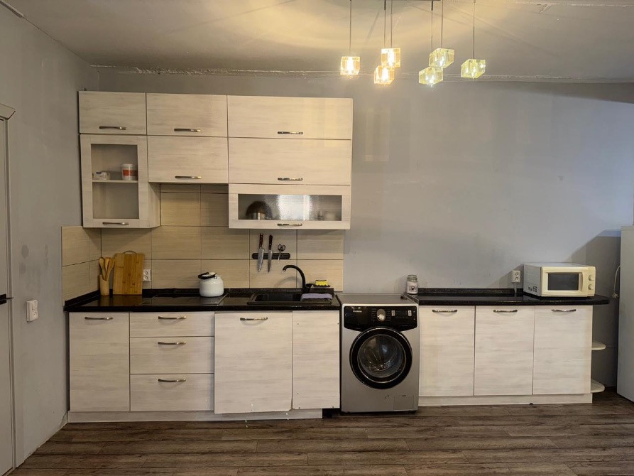 Кухня с современными шкафчиками, раковиной и стиральной машиной