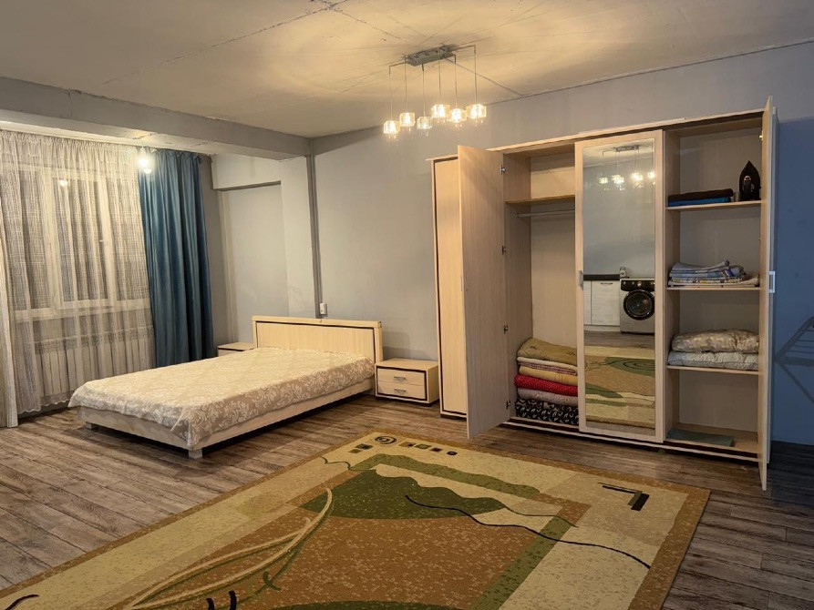 Интерьер спальни с кроватью и шкафом, большое окно