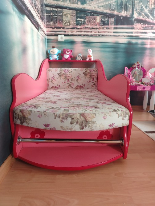 Удобная детская кроватка с декоративными деталями и цветочным матрасом