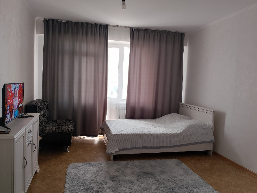 Фото спальни с кроватью, телевизором и шторами