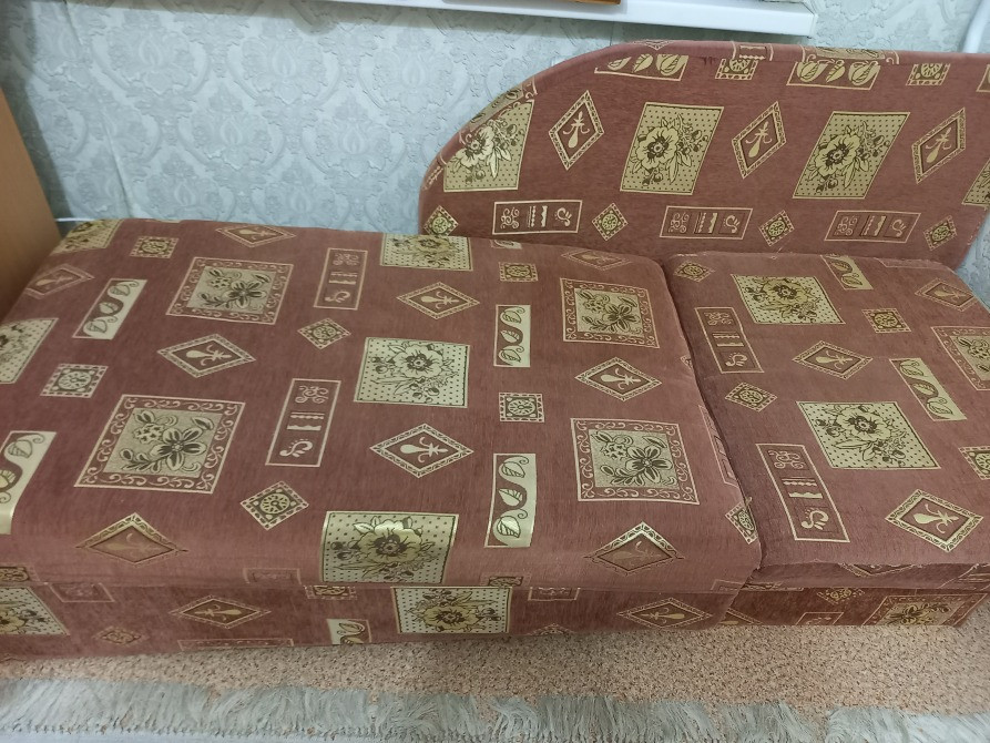 Фотография дивана с характерным покрытием и формой, расположенного в уютной обстановке