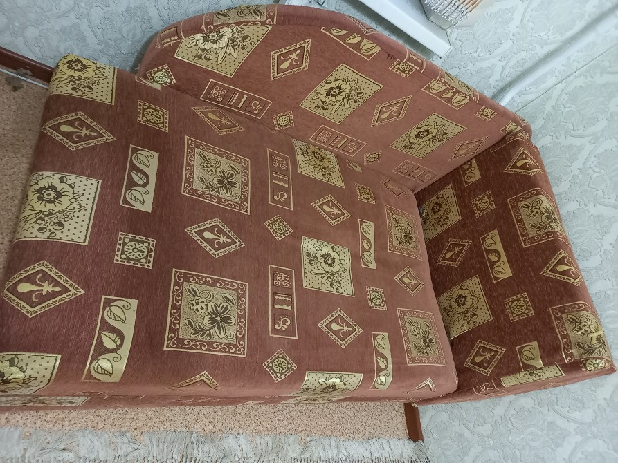 Вид сверху на угловой диван с характерным узором, расположенный в комнате