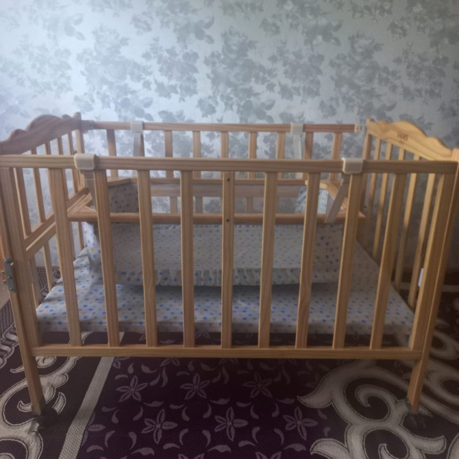 Детская кроватка из дерева с открытой конструкцией и мягким матрасом