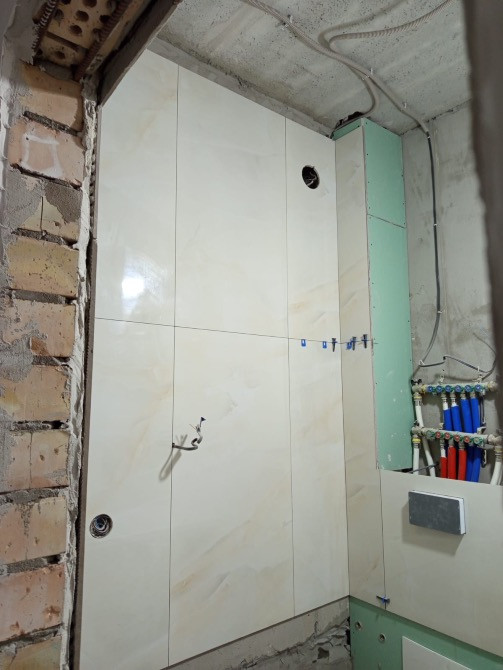 Сантехниканы орнатуға дайын плиткамен ванна бөлмесі