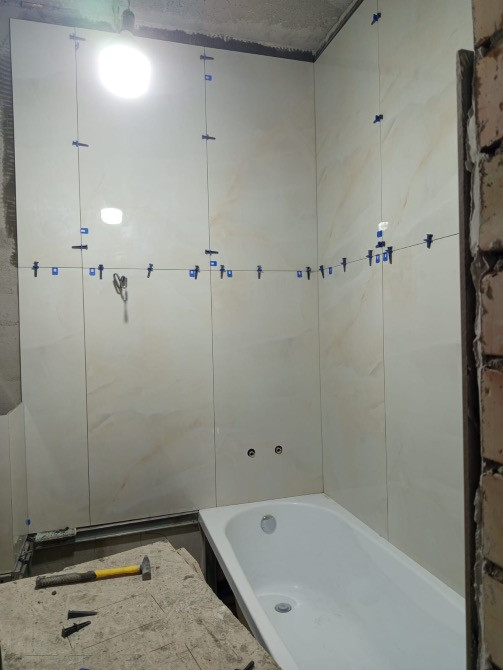 Ванна орнатылған ванна бөлмесінде плиткаларды төсеу процесі