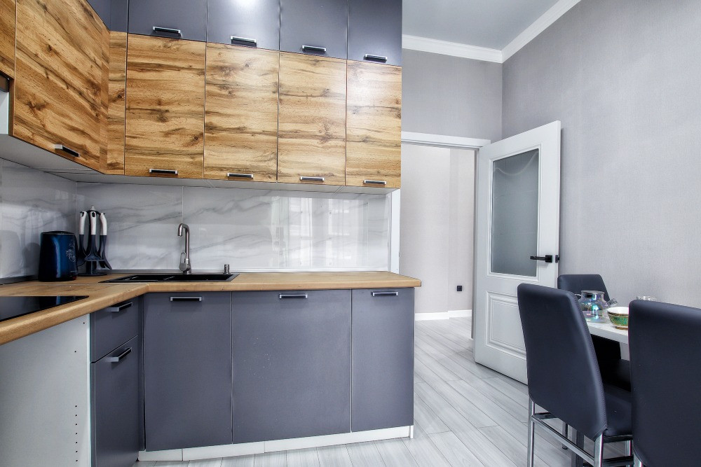 Современная кухня с деревянными и серыми шкафами