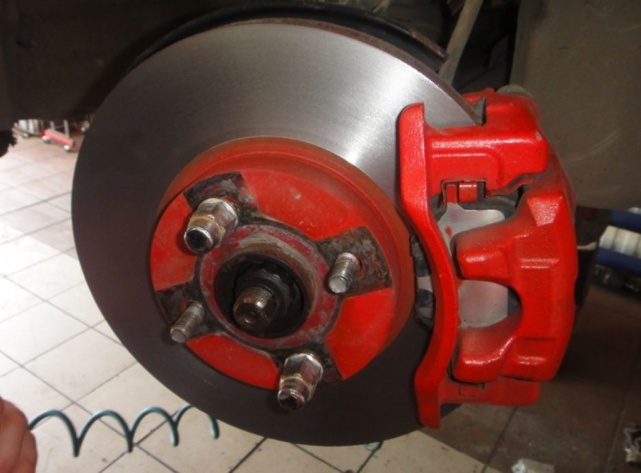 Қызыл тежегіш құлақшалармен орнатылған тежегіш диск