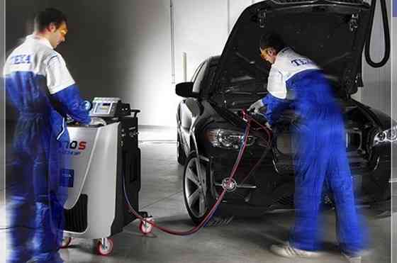 Сервисные работники выполняют техническое обслуживание автомобиля в автосервисе
