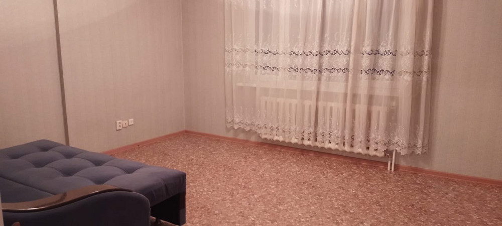 Перделері мен диваны бар қонақ бөлмесі