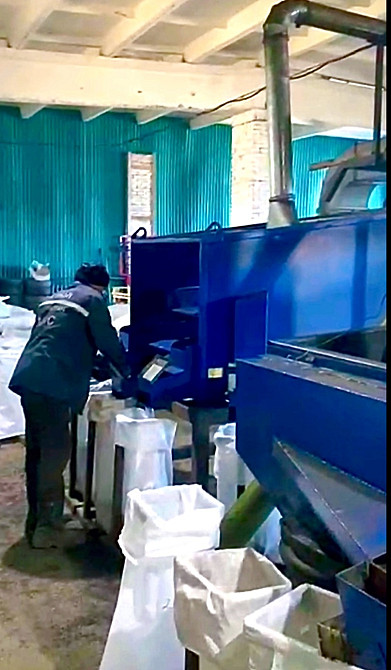 Өндіріс желісінде материалдарды қаптау өсіретін жұмысшы