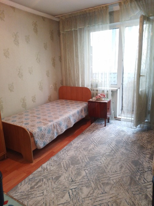 Бір адамдық кереуеті мен балкон есіктері бар жатын бөлме