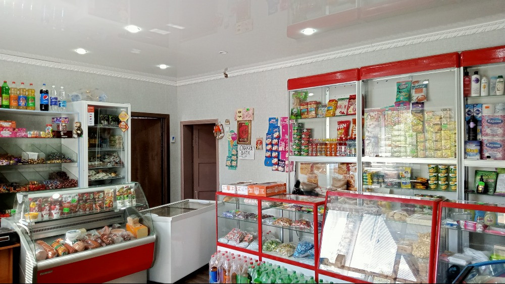 Дүкен интерьері, өнімдер мен сусындарға толы сөрелермен