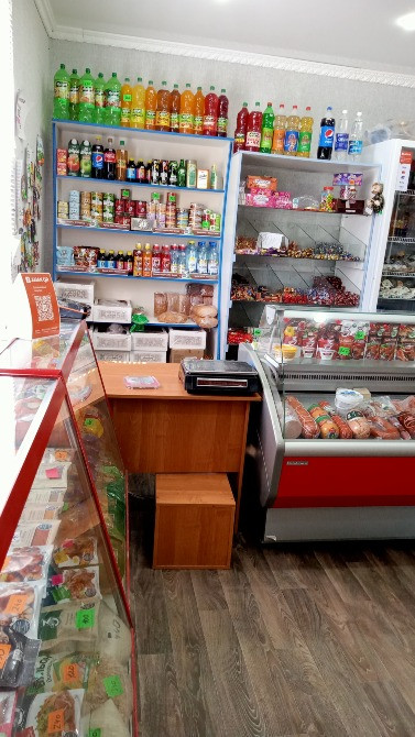 Дүкендегі сусындар мен закускалармен толтырылған сөрелердің көрінісі