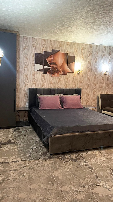 Комната с кроватью и декоративной фотографией на стене