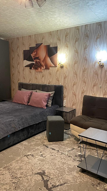 Огляд кровати с подушками и рядом мебели