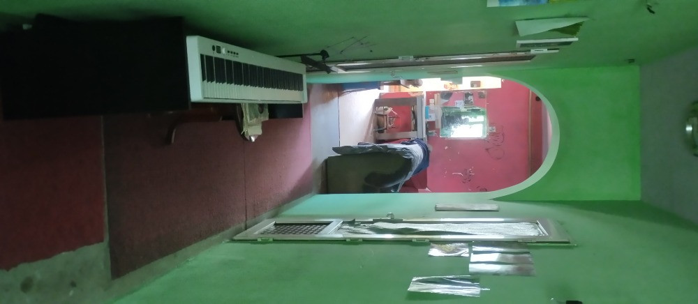 Жасыл қабырғалары бар бөлменің интерьері және еденде музыкалық аспабы бар