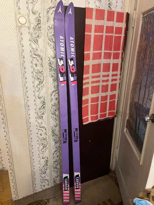 Сноуборды Atomic 3D на красной и белой облицовке, стоящие рядом с дверью