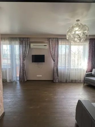 Гостиная с большими окнами, кондиционером и телевизором
