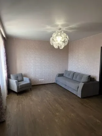 Диван мен дөңгелек шамы бар қонақ бөлмесінің бұрышы