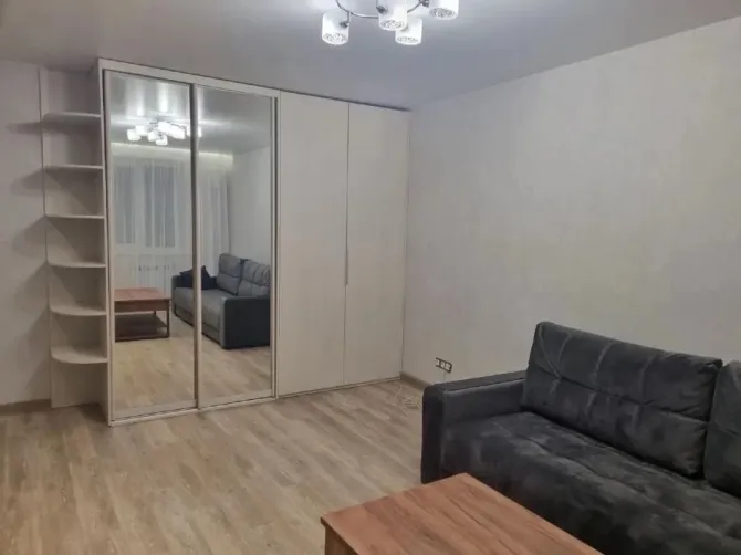 Заманауи қонақ бөлме диванмен және айна шкафымен