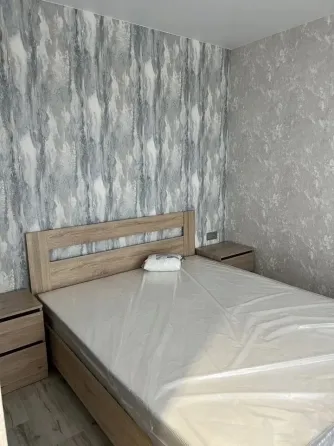 Спальня с кроватью и обоями