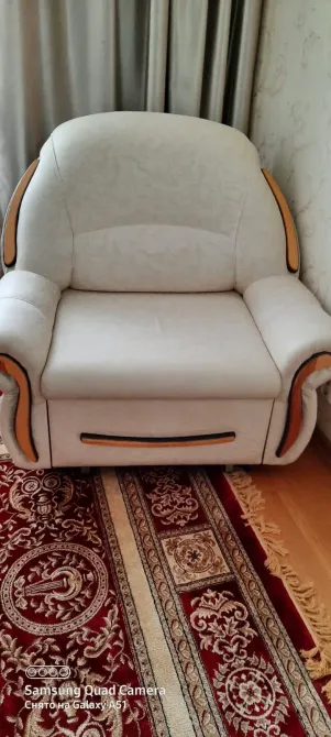 Ақ кресло кілем мен қабырға фонында