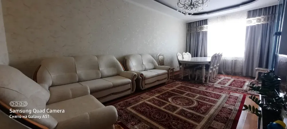 Жарқын дивандар мен асхана аймағындағы үстел ыңғайлы бөлмеде