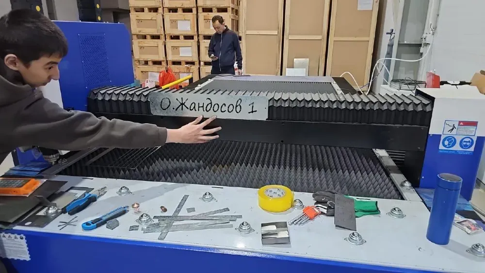 WOODMAN Fiber Tech 3015HT станогымен жұмыс зонасы және үстелдегі адам