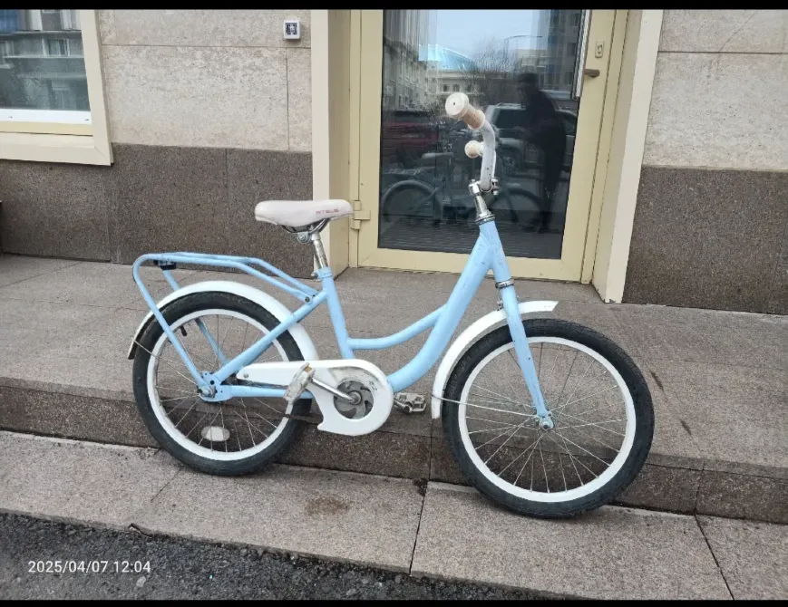 Синий велосипед на тротуаре перед зданием