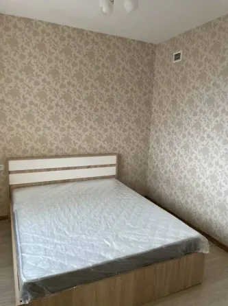 Спальня с односпальной кроватью и обоями в цветочный принт