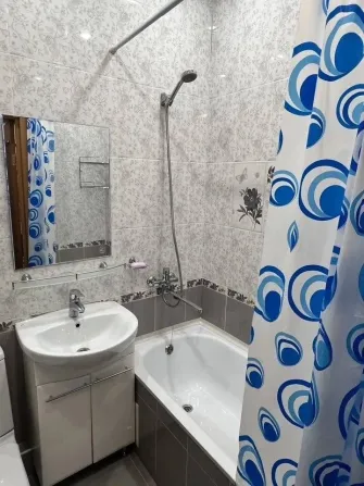 Жуыну бөлмесі душ кабинасымен, раковинамен және душ пердесімен