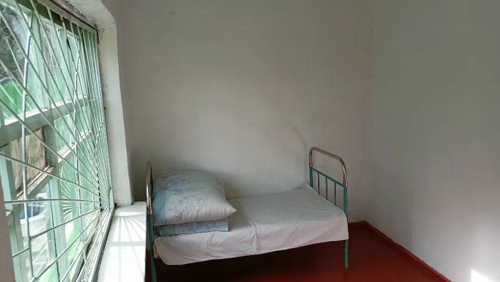 Пустая комната с одной кроватью и большим окном