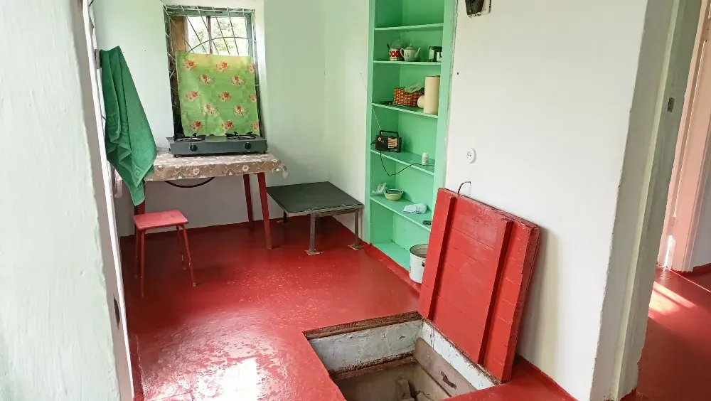 Кухня с столом и ящиками, в полу имеется люк