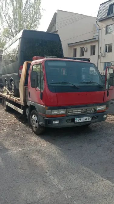 Грузовик с подъёмником, транспортирующий автобус