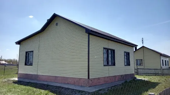 Вид на боковую сторону жилого дома с желтыми стенами