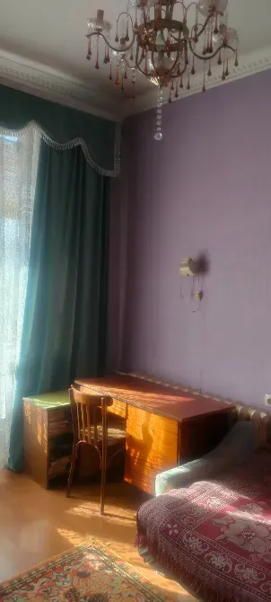 Спальня с письменным столом и кроватью, оформленная в светлых тонах