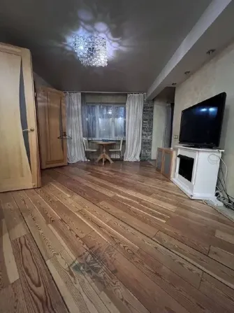 Телевизоры және ас үстелімен қонақ бөлмесі