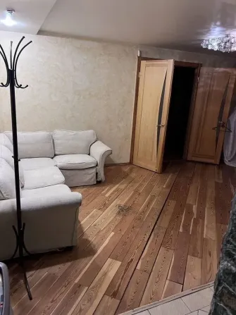 Кең қонақ бөлмесі диван және ағаш еденмен
