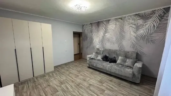 Современный интерьер гостиной с диваном и декором из листьев